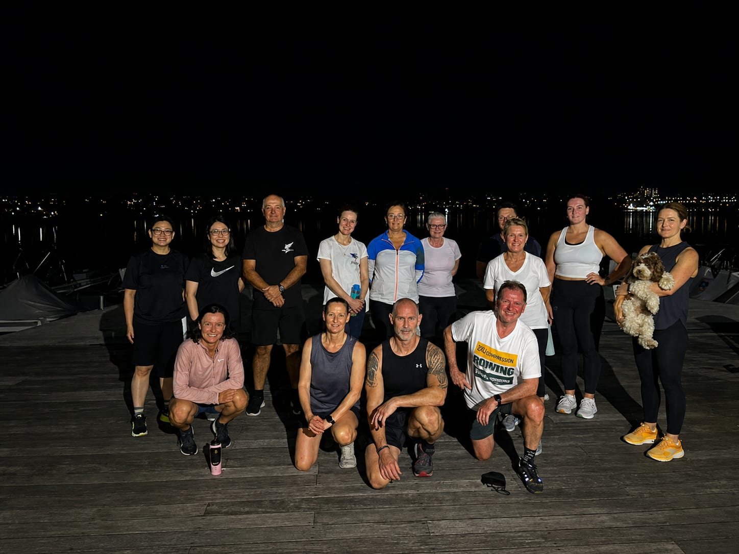A Row Club crew of everyday rowers gathered on the wharf after an evening session