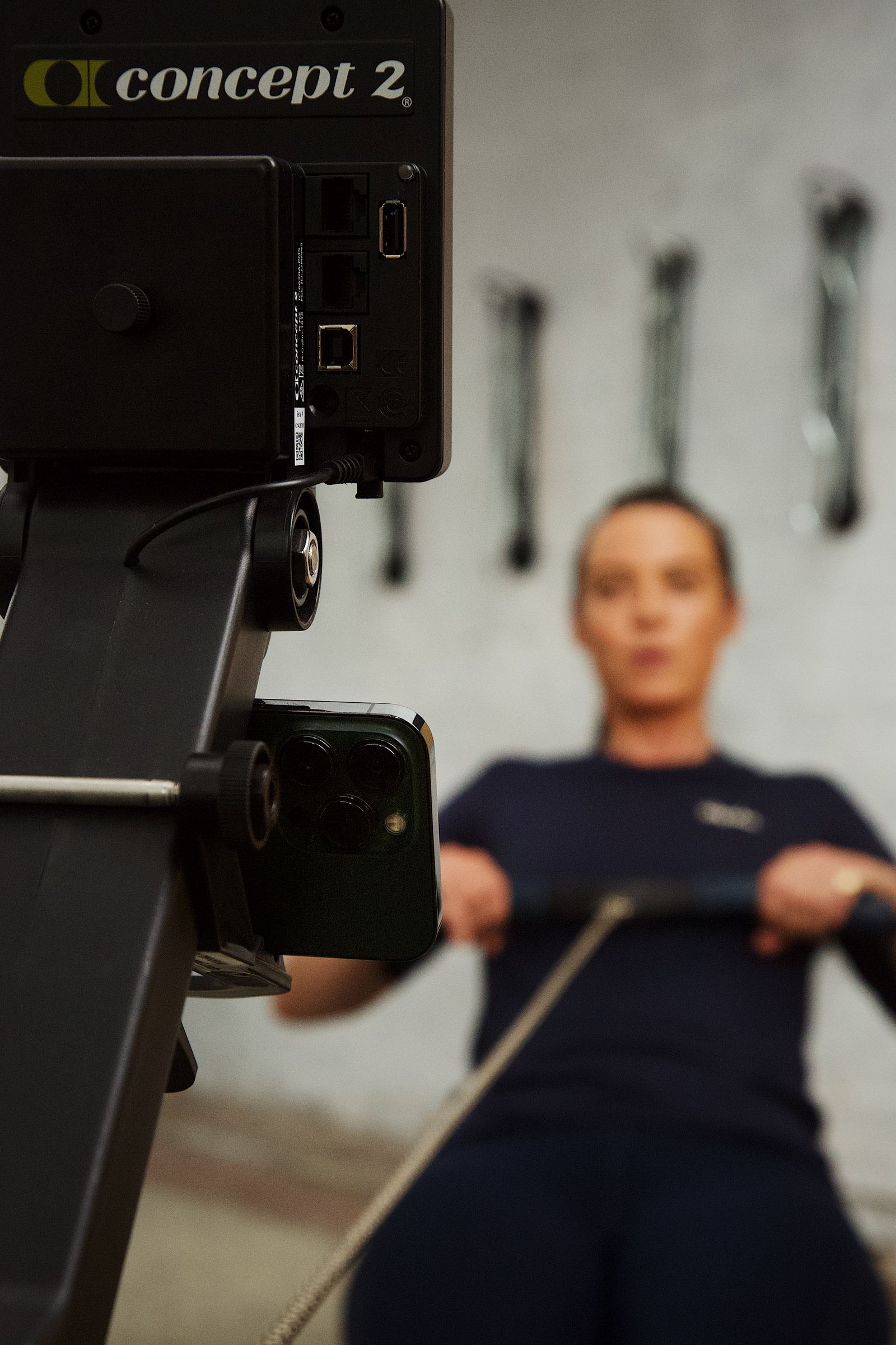 Close detail of a Concept2 PM5 monitor and phone mount in low warm winter light